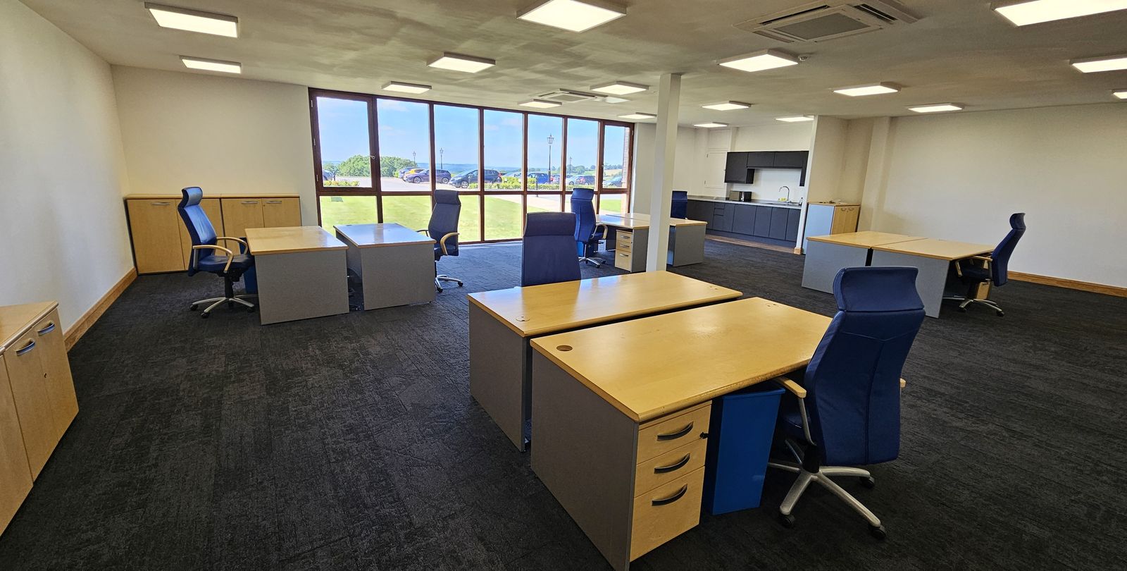 Office suite to let at Grovelands Business Park, Northamptonshire, showing desks, kitchenette and countryside view